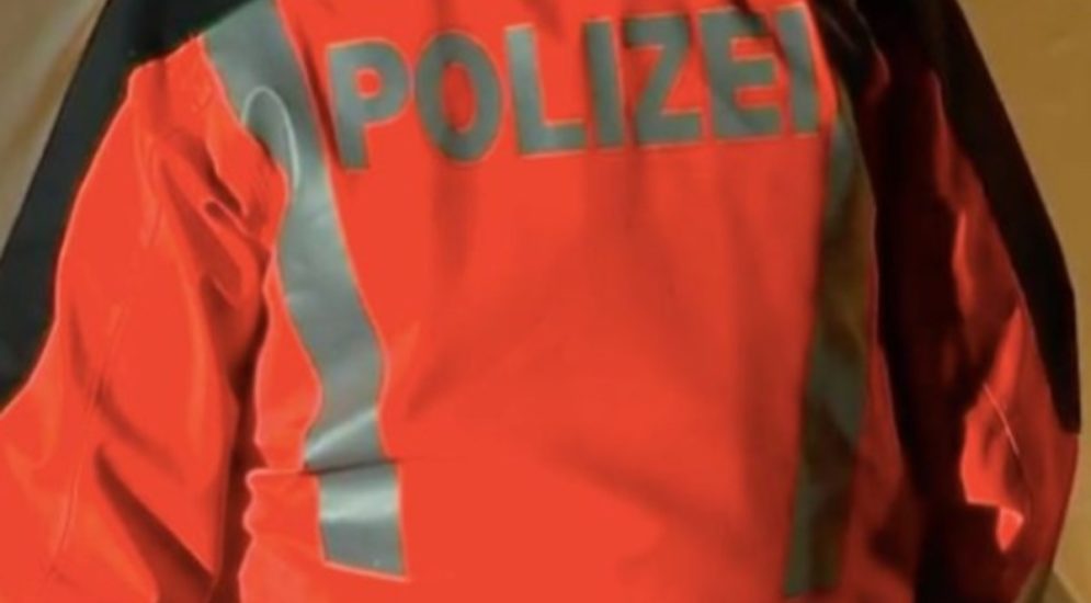 polizist in orangner jacke symbolbild