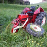 roter traktor auf wiesland liegend