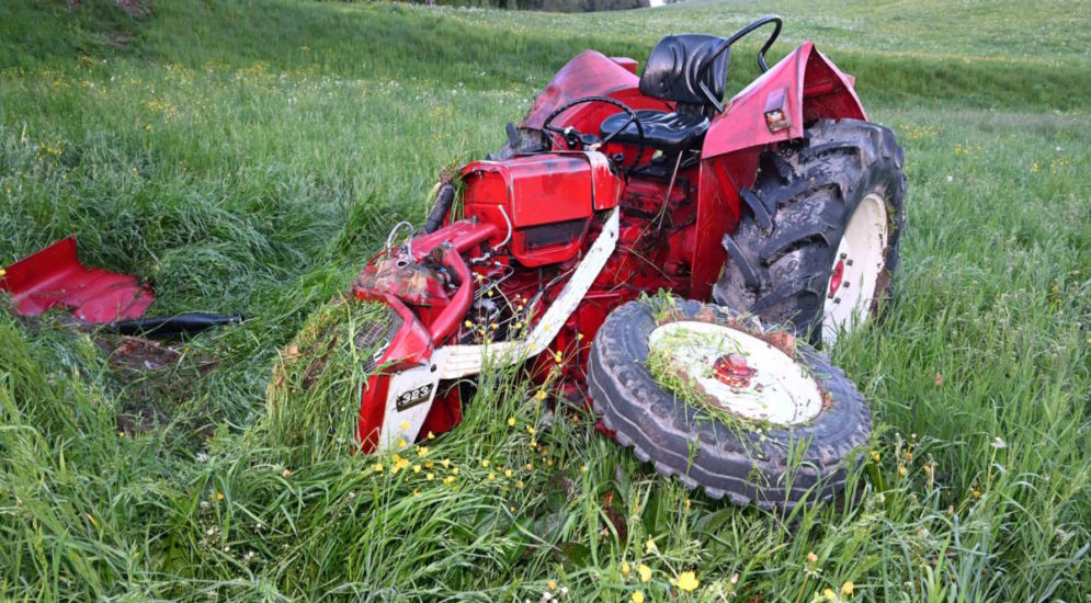 roter traktor auf wiesland liegend