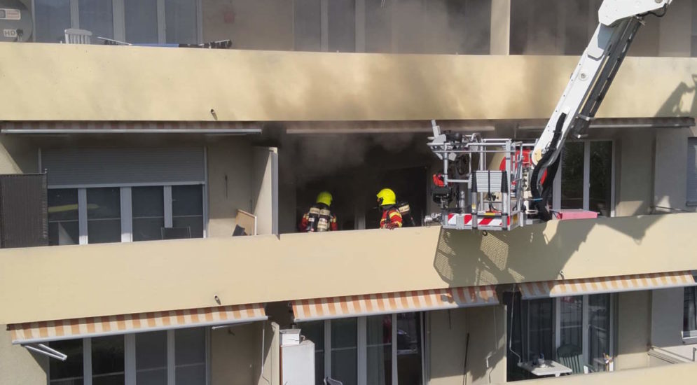 Feuerwehrleute auf rauchendem balkon