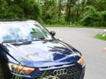 Blauer Audi steht in Kurve im Wald am Strassenrand, im Hintergrund ein Verkehrshütchen