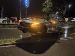 Mercedes mit eingeschalteten Scheinwerfern steht schräg, vorne aufgestützt auf einen halb umgeknickten Strassenpfosten